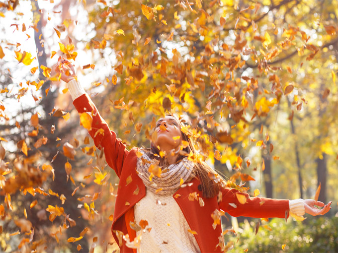 mujer bajo las hojas del otoño