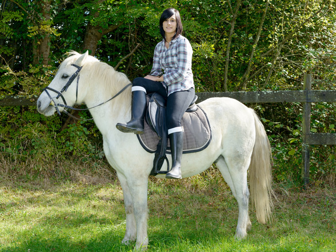 Mujer montando a caballo.