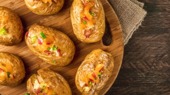 patatas asadas rellenas sobre mesa de madera
