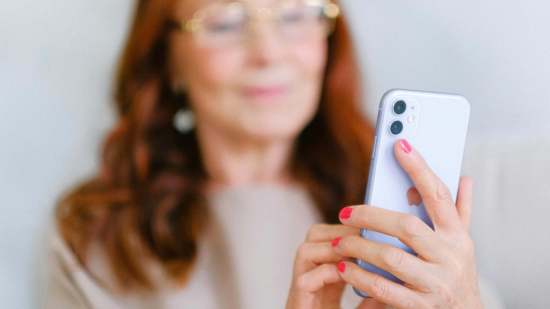 Mujer +50 configurando su teléfono