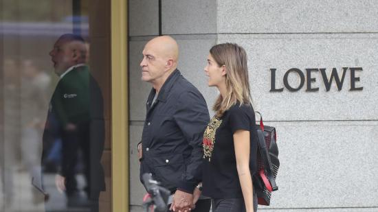 Personas caminando frente a una tienda de Loewe, con un diseño minimalista en su fachada.