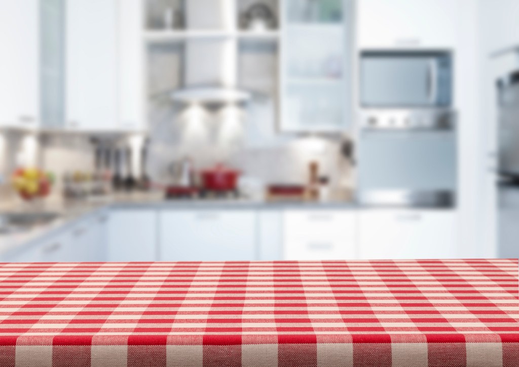Mesa cubierta con mantel rojo y blanco de cuadros - Imagen: iStock