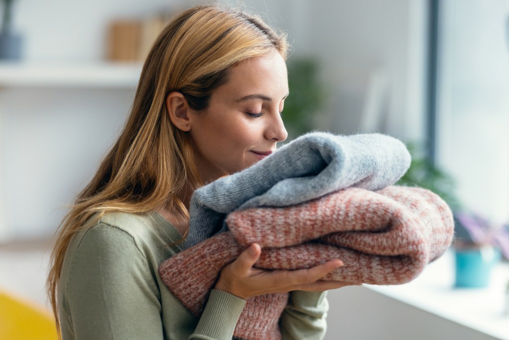Mujer oliendo su ropa con cariño (Marie Kondo) - Imagen: iStock