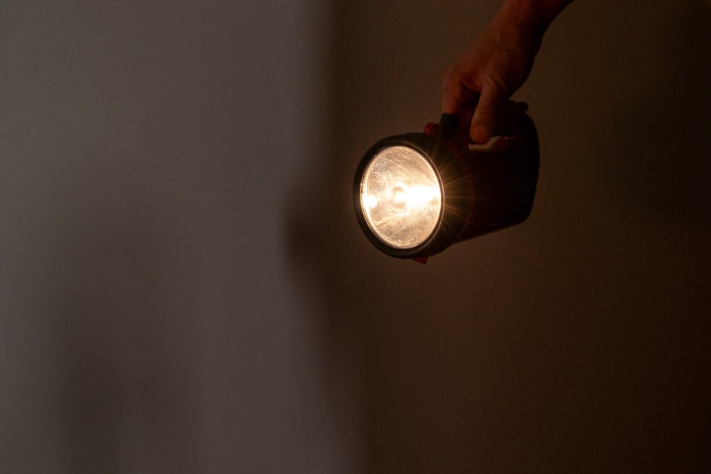 Linterna iluminando habitación a oscuras - Imagen: iStock